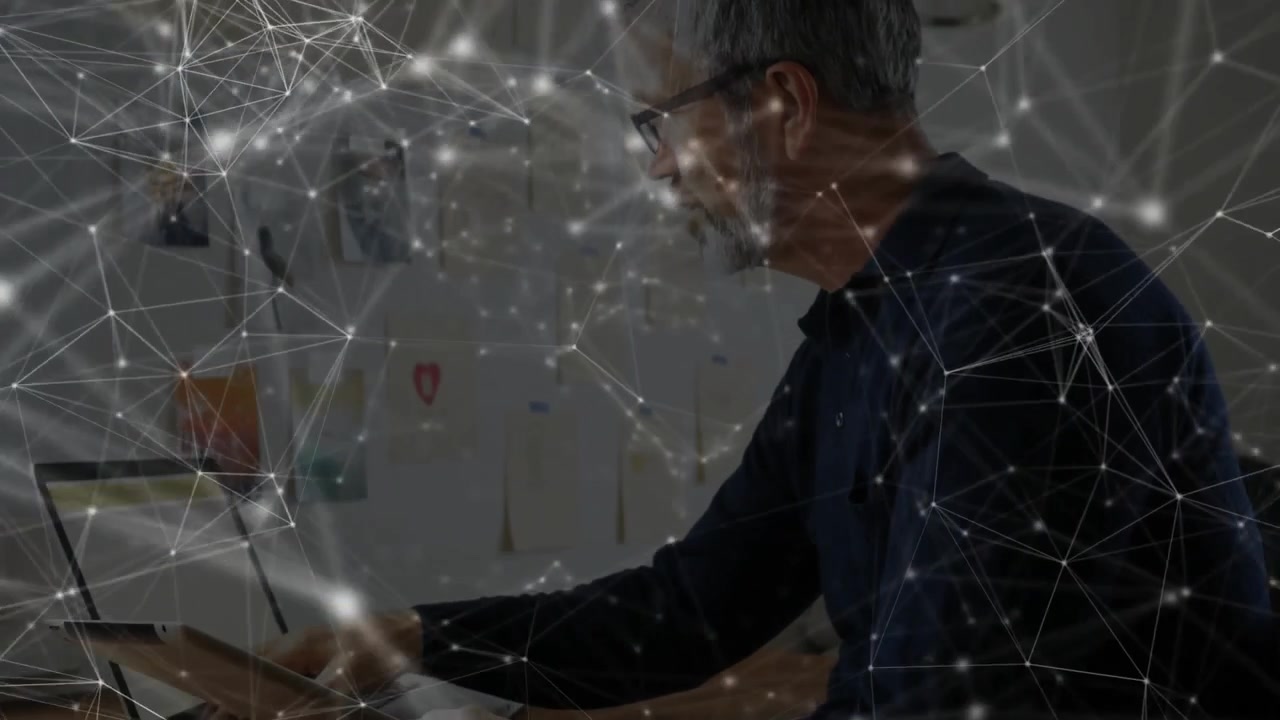 Office worker reading inspiration board then typing while tech network overlay intensifying