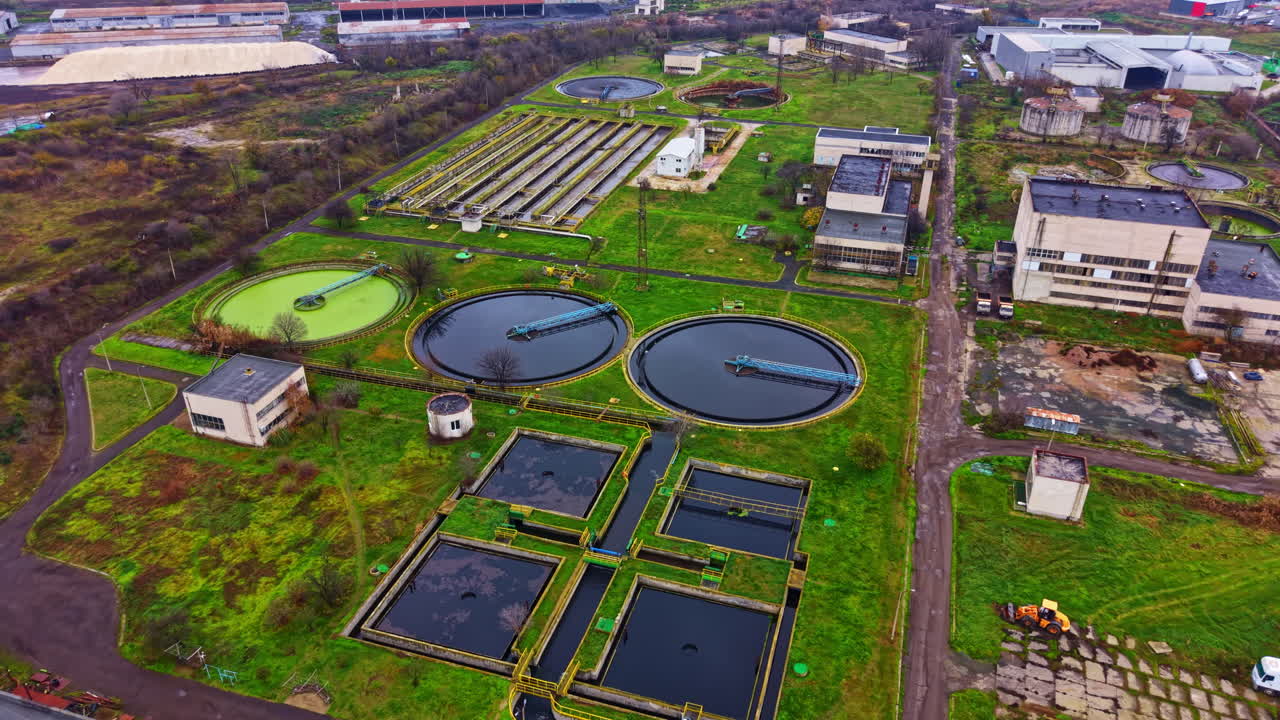 Water treatment facility with several tanks and processing units in an industrial area during the day