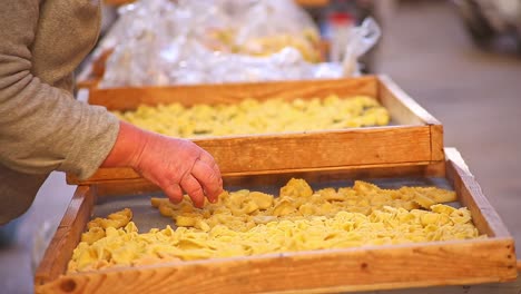 close up elderly lady selling pasta in authentic local italian market