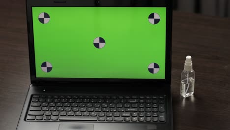 la mano toma la máscara de la computadora portátil con pantalla verde, llave de croma. coronavirus covid-19
