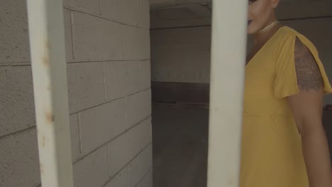 Beautiful woman in yellow dress inside white parking garage