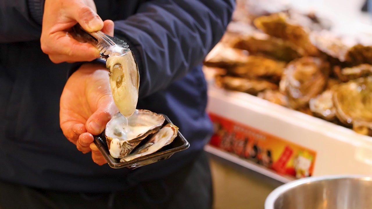 Vendor Preparing Fresh Oyster for Customer at Seafood Market