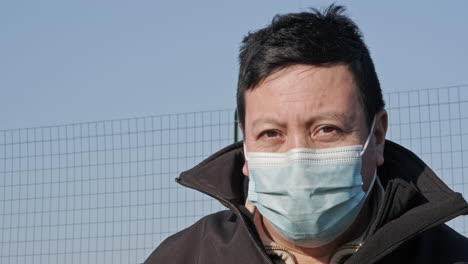 Ecuadorian-Man-Wearing-Facemask-And-Looks-At-Camera-With-Blue-Sky-In-Background