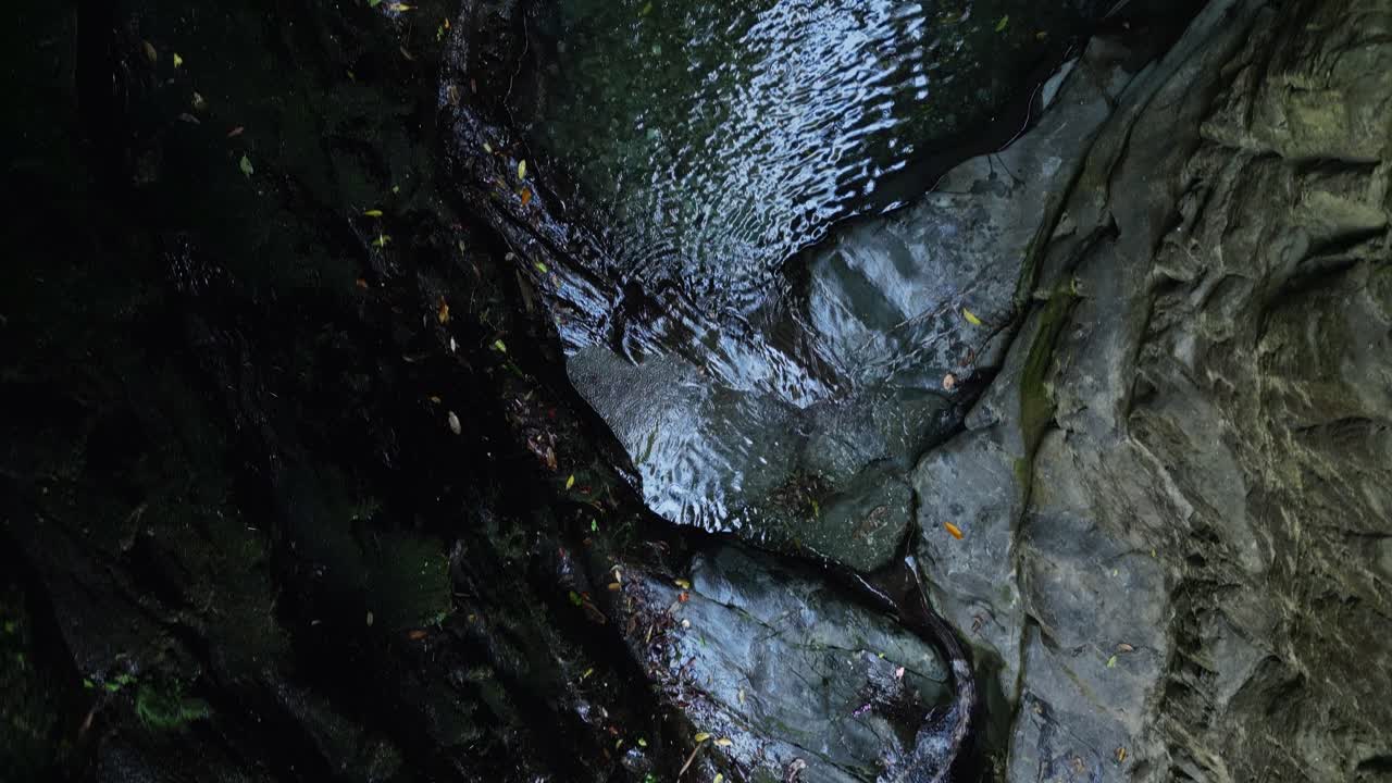 perspectiva del avión no tripulado de arriba hacia abajo de la cascada que corta a través de la roca lisa del río