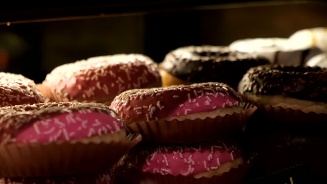 Donuts assortiti con glassa al cioccolato, glassa rosa e codette colorate