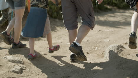 legs closeup of hiking family walking along dirt road together