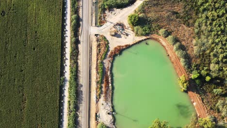 green spring valley with long shadows along a straight road and large farmland in northern israel on a sunny day