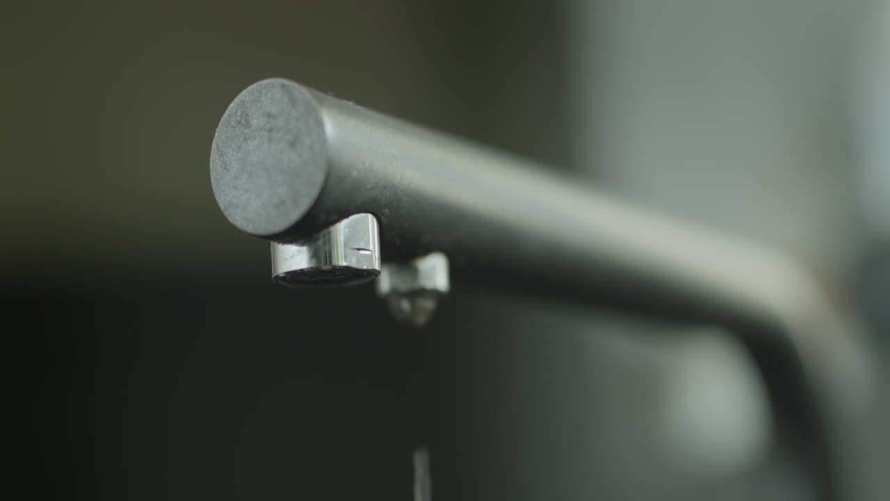 el agua está goteando del grifo de la cocina. fuga de agua en el hogar. video en cámara lenta 4k