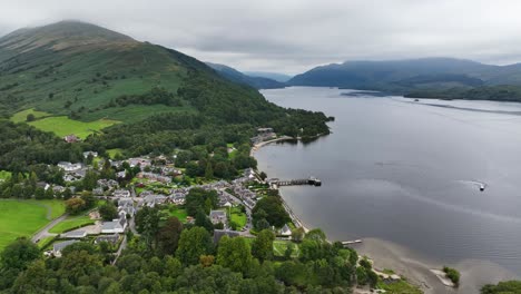 aerial pan around luss village next to loch lomond with cloud covered ben lomond in the background