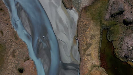 top aerial view over colorful natural landscape, revealing mountains in distance