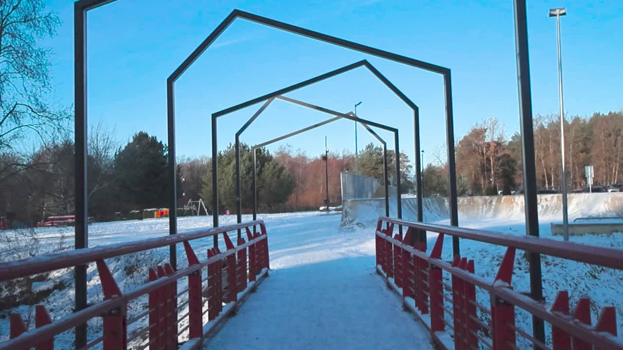 겨울의 은 날에 다리를 건너는 fpv 또는 1인칭 전망: 다리는 두꺼운 색의 아름다운 눈과 얼음으로 여 있으며 레일링은 빨간색입니다.