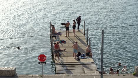 Junge-Kerle-Springen-Vom-Hafen-In-Guatemala,-Flores