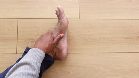 person holding painful ankle