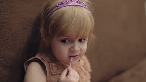 Happy-three-years-old-girl.-Cute-blonde-child.-Brown-eyes.-Girl-does-her-makeup