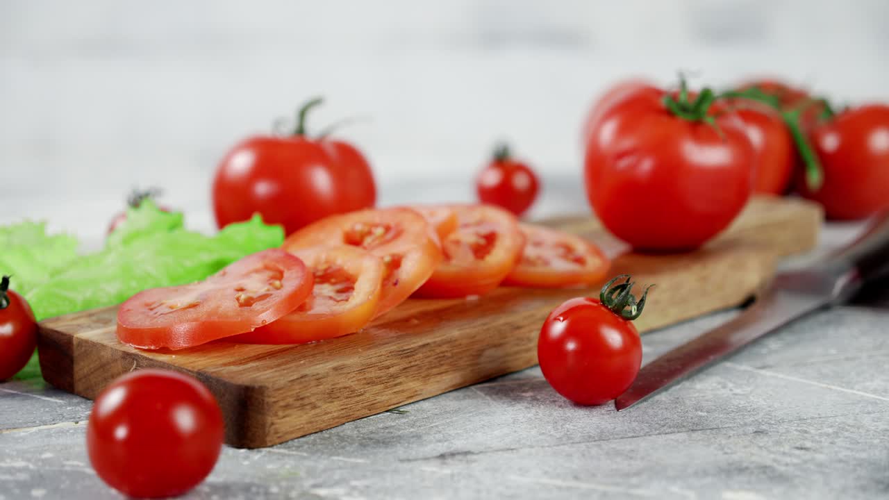 Slices of ripe tomato on wooden cutting Board slowly rotate.