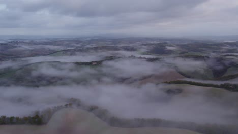 Sanfte-Hügel-Der-Toskana,-Vor-Sonnenaufgang-In-Nebel-Gehüllt,-Luftaufnahme