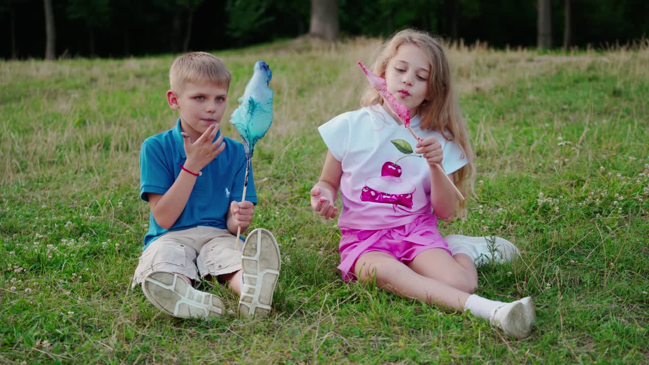 Kids eating cotton candy. Adorable little children eating candy floss outdoors at park