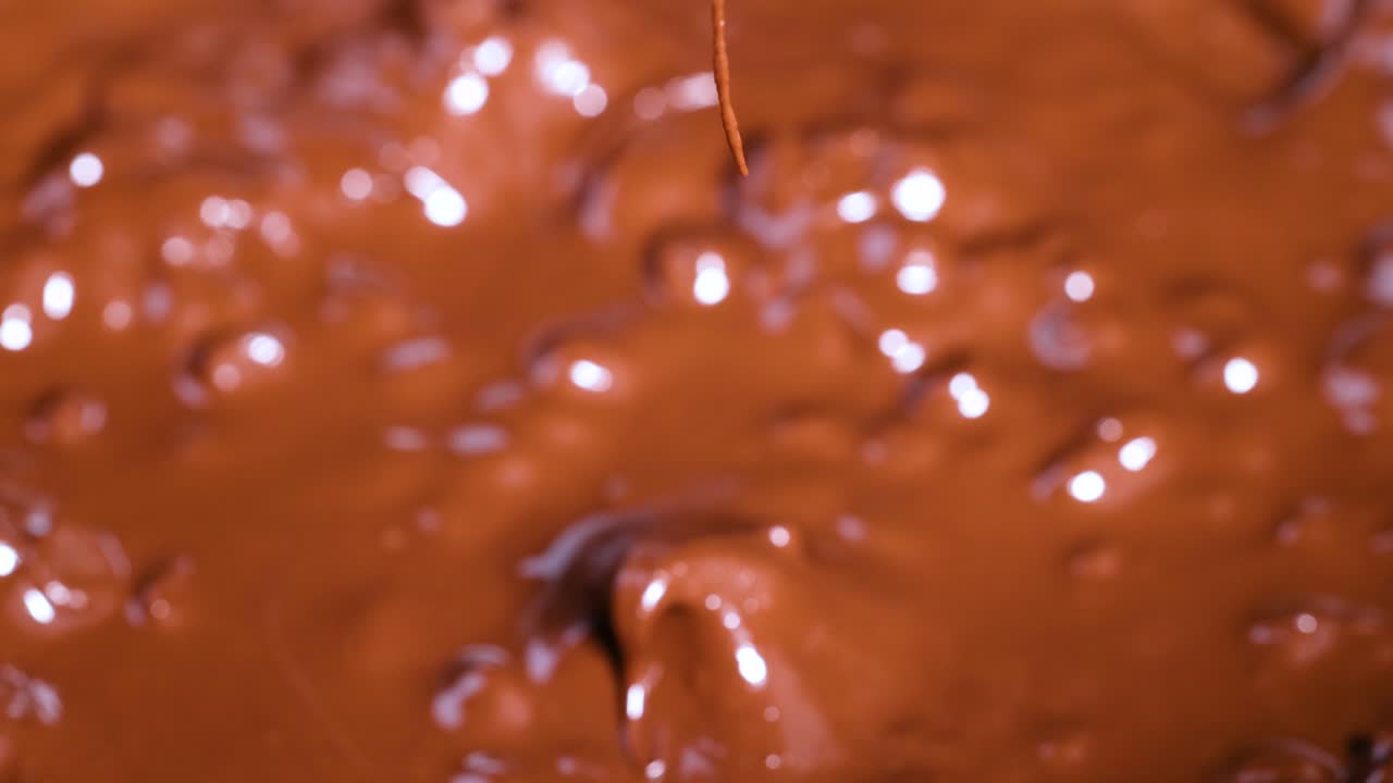 Spoon stirring melting chocolate chips smoothly