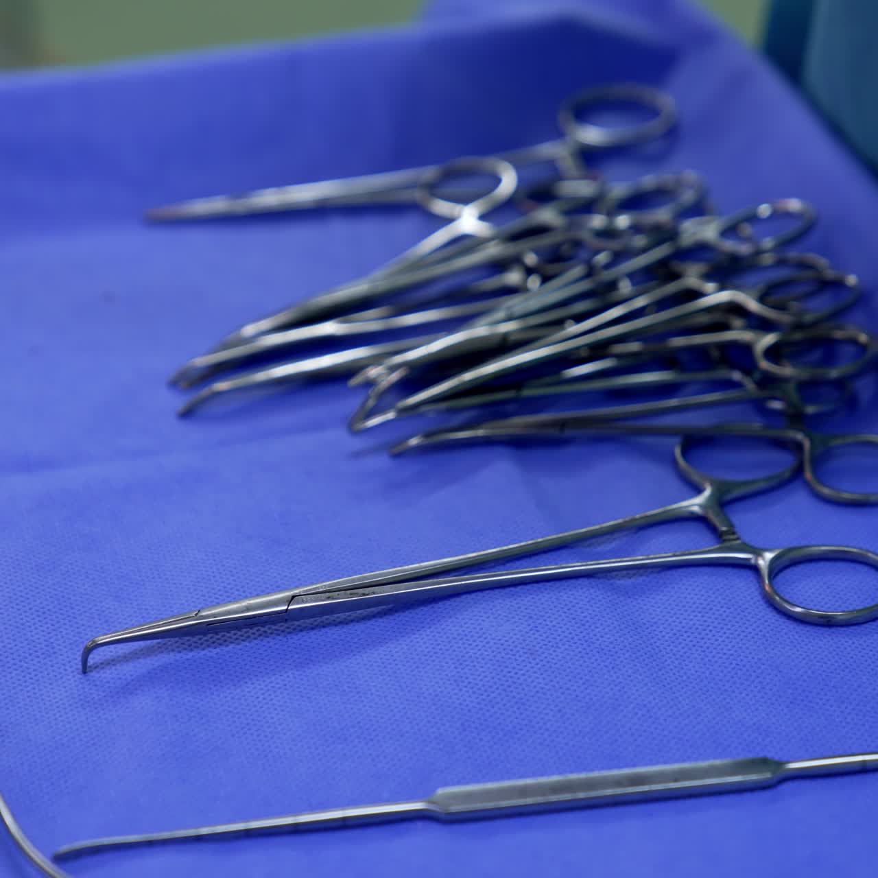 Diversity of metal tools prepared for neurosurgical operation. Instruments on the table covered with blue sheet. Close up