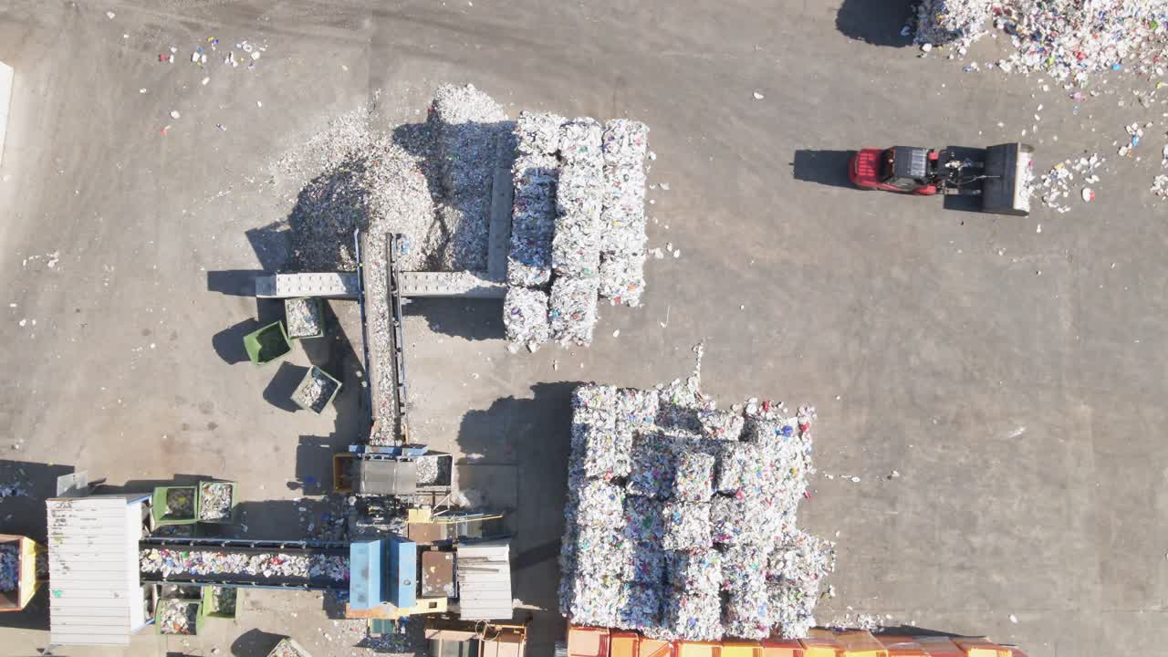 Aerial top-down of plastic trash processing factory with divide lines of waste
