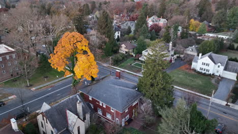 Descending-aerial-approach-to-rear-of-red-brick-single-family-home-in-suburban-American-neighborhood-community