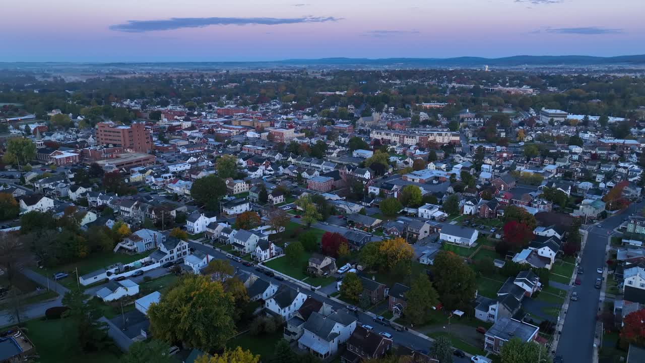 Wide aerial shot of American town during autumn sunrise at dawn