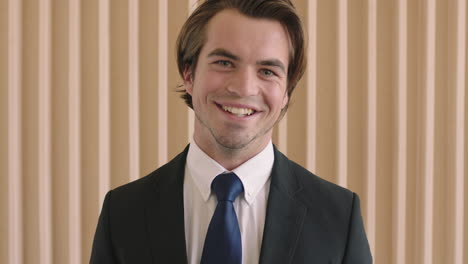 close up portrait of attractive young successful businessman smiling happy wearing stylish suit positive male entrepreneur