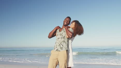 pareja afroamericana hombre acurrucado en la playa