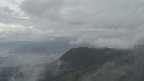 drone aerial rising flying through clouds over the mountains