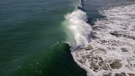 4k footage of a large wave breaking, off the pier, in huntington beach california