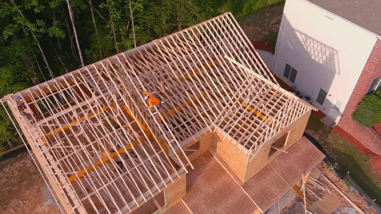 hombre en el techo de un nuevo hogar siendo enmarcado