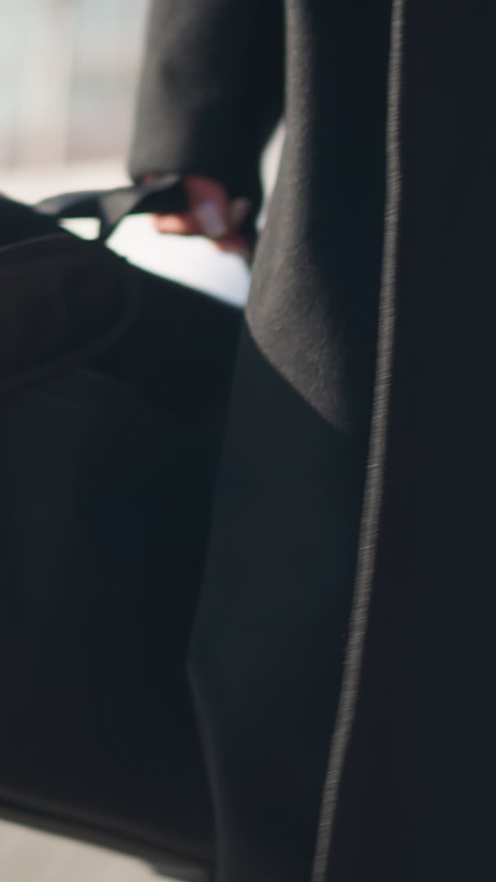 primer plano de una bota de cuero y un elegante detalle del abrigo, mostrando una pierna en medias transparentes, que exuda elegancia y sofisticación en una calle urbana con un fondo borroso con edificios y bicicletas