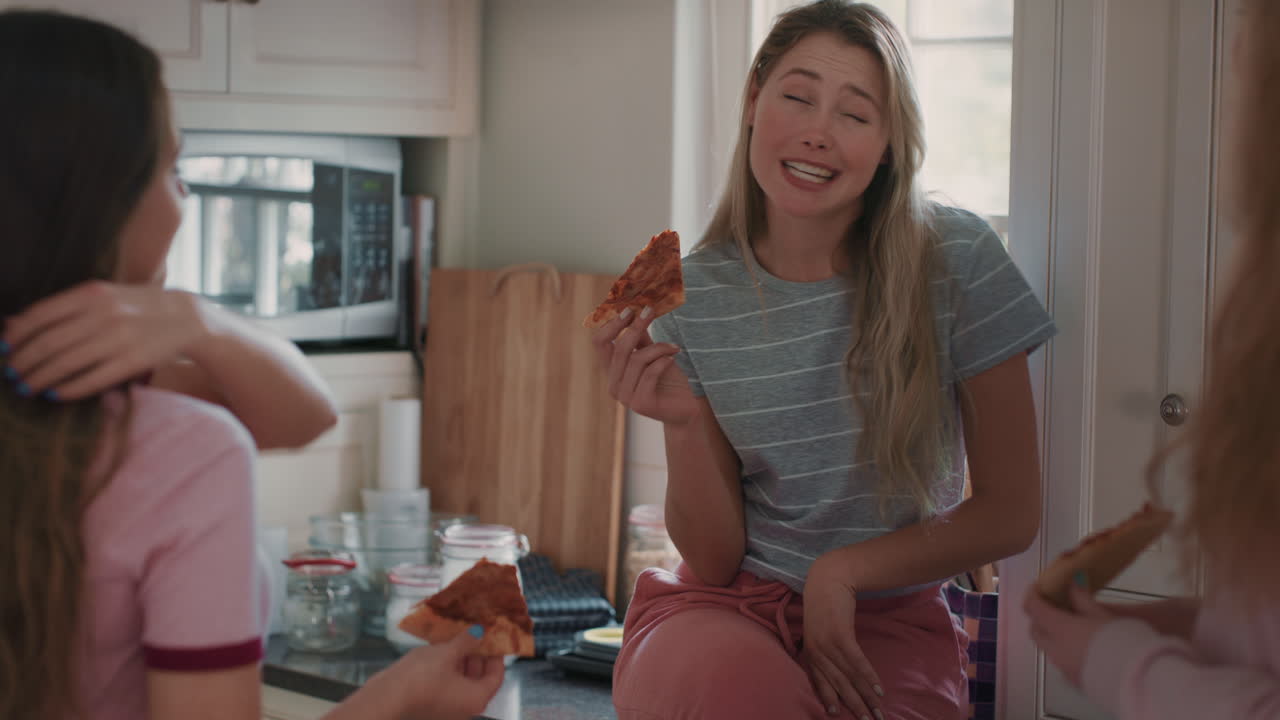 십대 소녀 들 이 부 ⁇  에서 피자를 먹고 즐겁게 함께 채팅 하고 소문 을 나누고 친구 들 과 어울리며 집 에서 휴식을 즐기고 있다