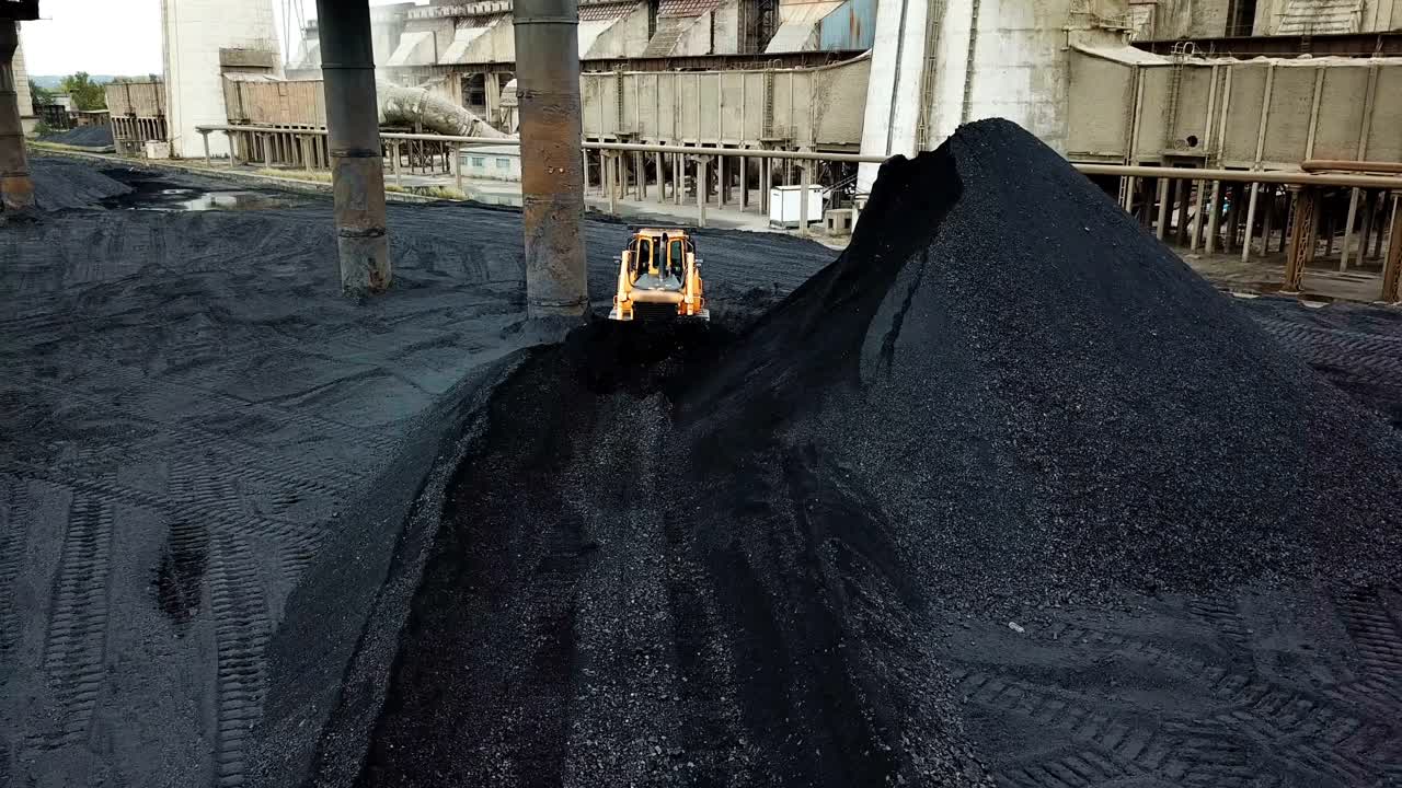 Crawler bulldozer sorts coal. Industry. Aerial view.