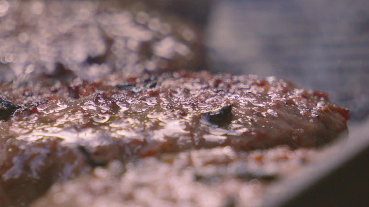 Close Up of Delicious Juicy Beef Burgers Seasoned with Pepper on Hot BBQ with Heat Distortion Rising from Grill Below. High Quality ProRes in Natural Light.