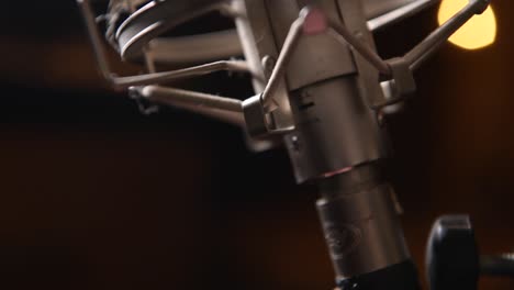 conectando un cable xlr a un micrófono de cinta vintage durante una sesión de grabación vocal en el estudio