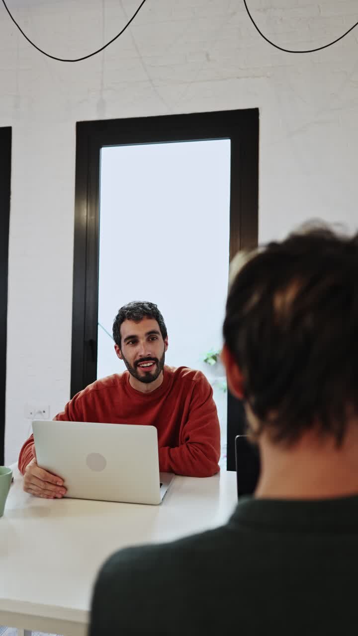 Young Man Talking and Gesturing During a Business Meeting