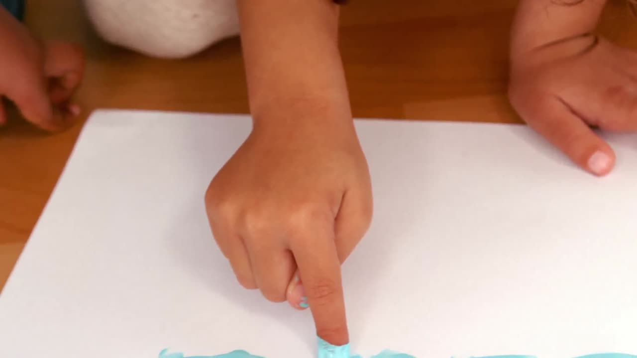 Kids finger painting on sheets of paper