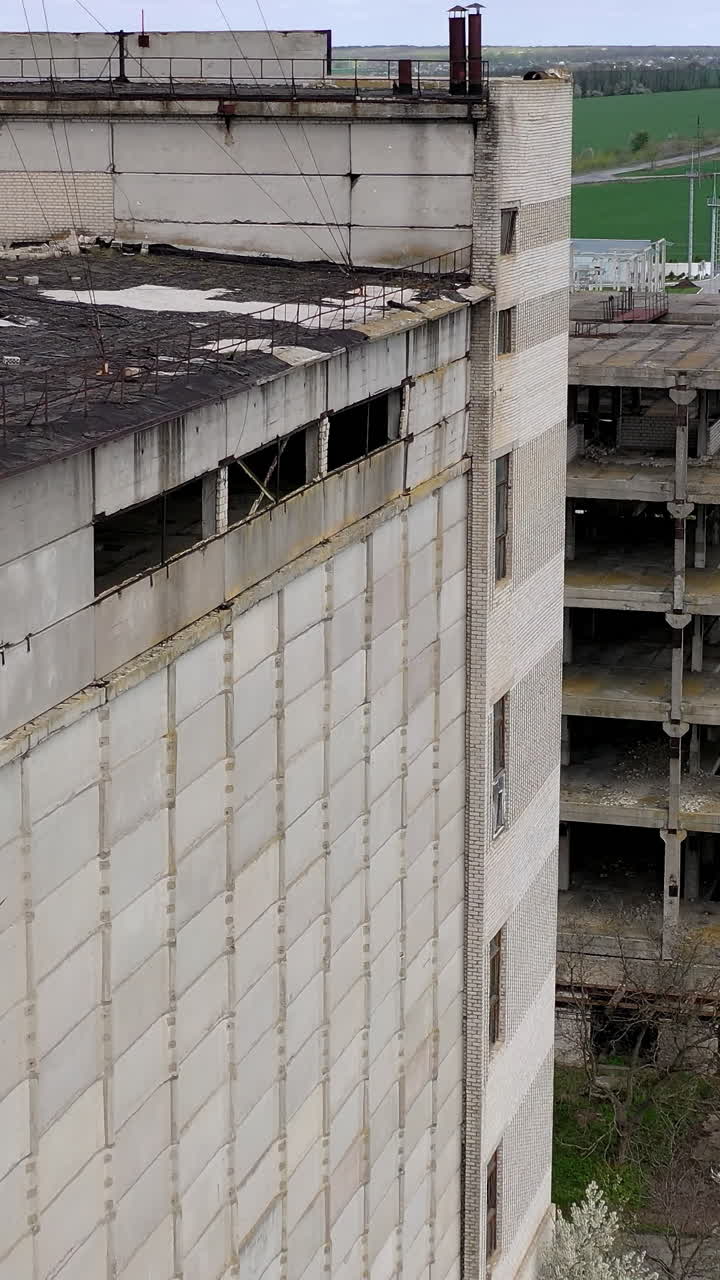 Aerial shot of crashed ruined factory in the city. Apocalypsis aero view city. Vertical video