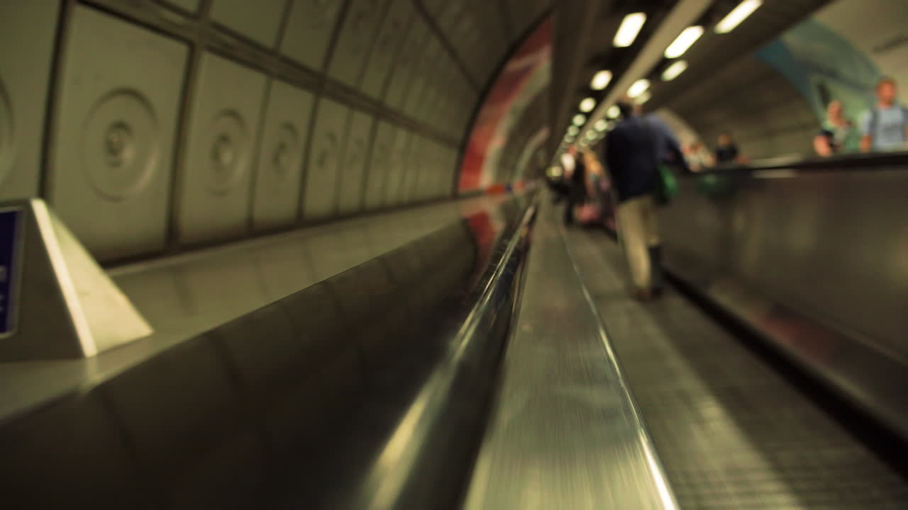 런던 지하철의 수평 에스컬레이터를 타고 여행하는 누군가의 관점 샷