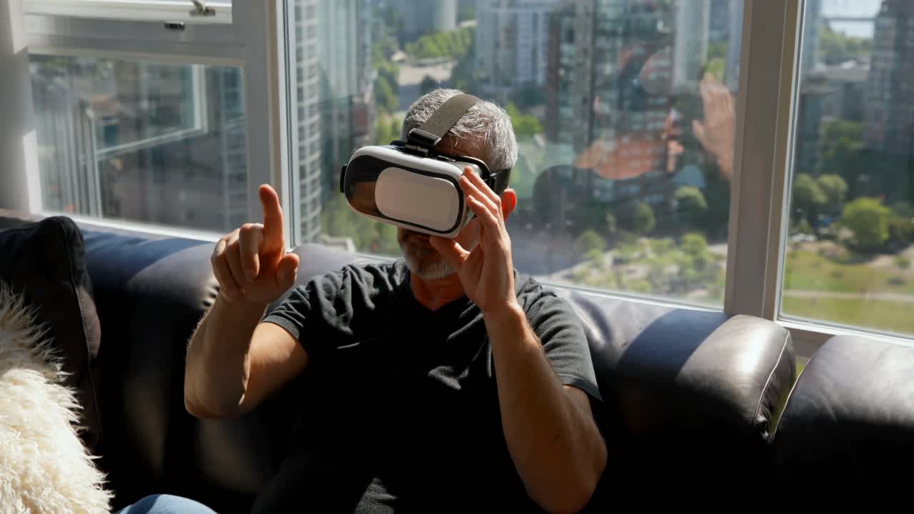 hombre usando auriculares de realidad virtual en el sofá 4k