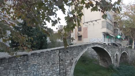 view of old pedestrian tanners' bridge in tirana, albania - push in wide shot