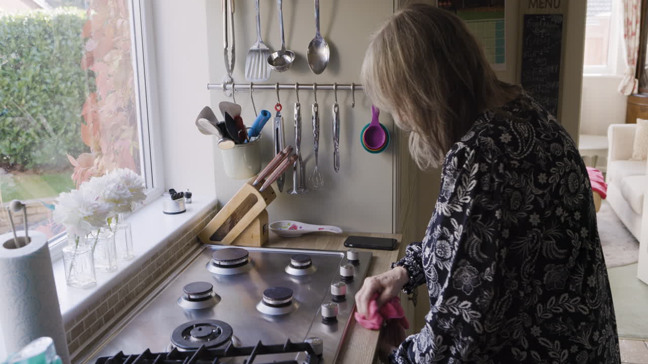 Woman cleaning a cooktop in a kitchen