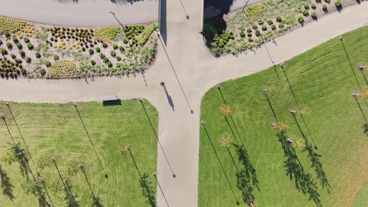 Symmetrical park geometry and soft tree shadows with single walker in sunlight