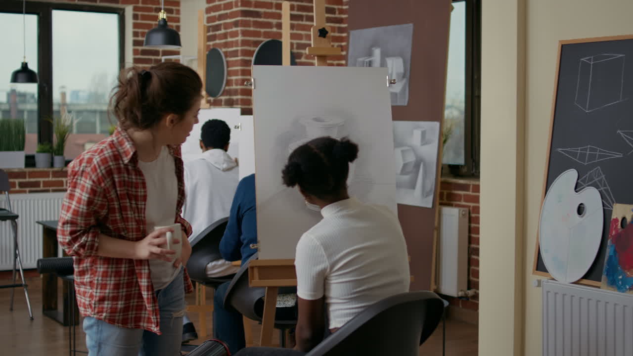 Young teacher giving artistic advice to african american woman