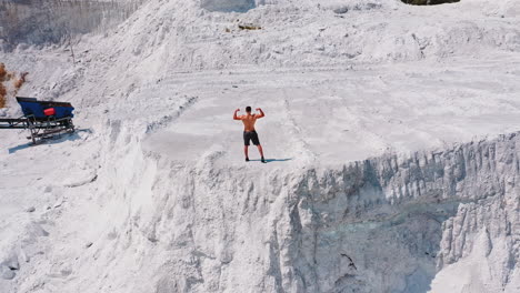 model man with naked torso. aerial view of attractive young shirtless athletic muscle man standing on mountain