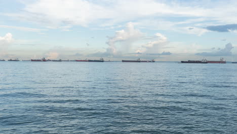 East-Coast-Beach-Singapore,-with-ships,-boats-and-fishing-rods-in-frame-High-Quality-panning-timelapse,-hyperlapse