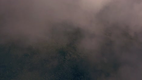 Wide-shot-of-aerial-drone-view-of-Retezat-Mountains,-Romania-seen-through-fog