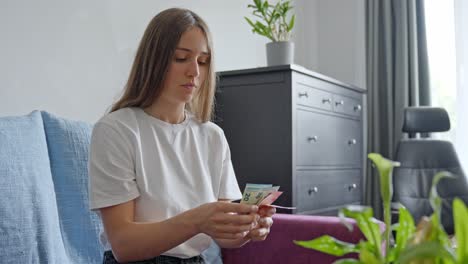 Mujer-Joven-Preocupada-Contando-Dinero-Antes-De-Pagar-Impuestos,-Vista-Frontal