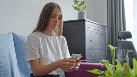 mujer joven preocupada contando dinero antes de pagar impuestos, vista delantero